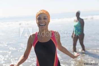 Portrait playful woman in bathing suit in sunny ocean surf
