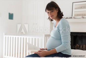 Portrait pregnant woman reading book on bed