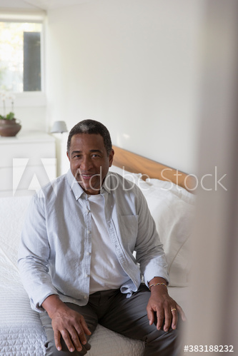 Portrait senior man sitting at edge of bed