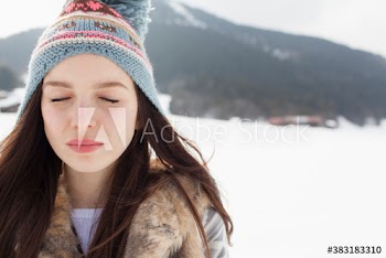 Portrait serene young woman in knit hat in snowy field