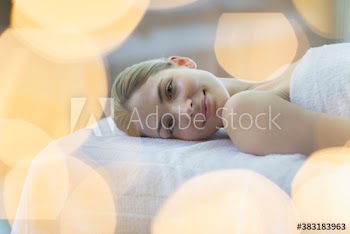 Portrait serene young woman relaxing on spa massage table