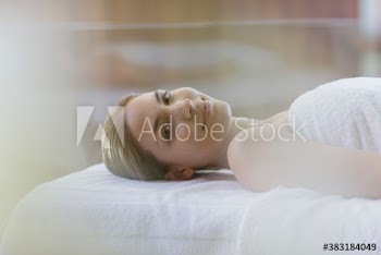 Portrait serene young woman relaxing on spa massage table