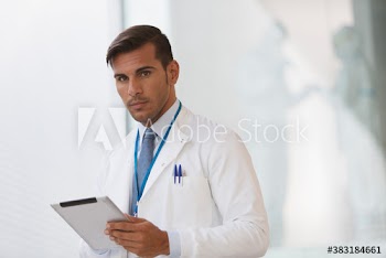 Portrait serious male doctor with digital tablet