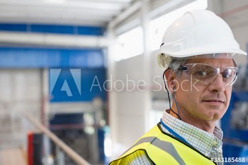 Portrait serious male factory worker in goggles and hard hat