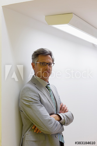 Portrait serious mature corporate businessman with arms crossed