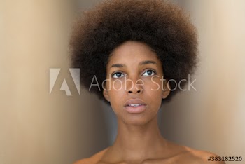 Portrait serious young woman with afro looking up