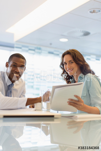 Portrait smiling business people discussing paperwork