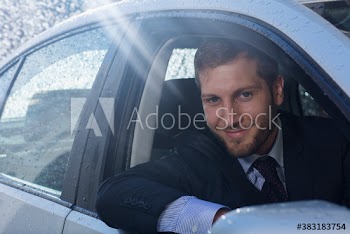 Portrait smiling businessman driving car in rain