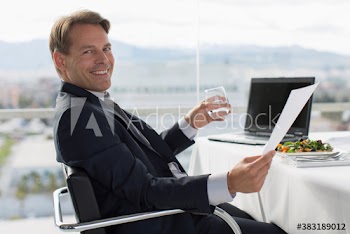 Portrait smiling businessman with paperwork at business lunch