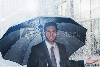 Portrait smiling businessman with umbrella in rain