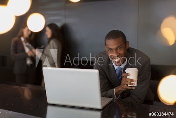 Portrait smiling businessman working at laptop and coffee