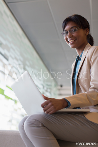 Portrait smiling businesswoman with laptop in office