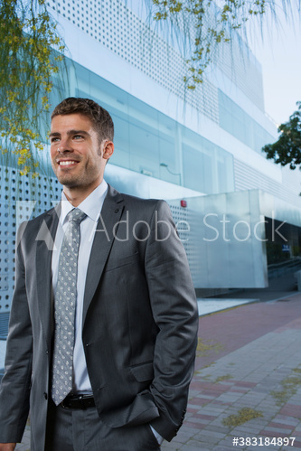 Portrait smiling corporate businessman outside office building