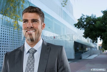 Portrait smiling corporate businessman outside office building