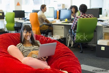 Portrait smiling creative businesswoman with laptop in beanbag chair