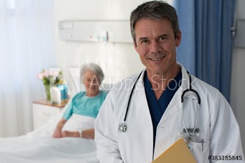 Portrait smiling doctor checking on senior patient in hospital room