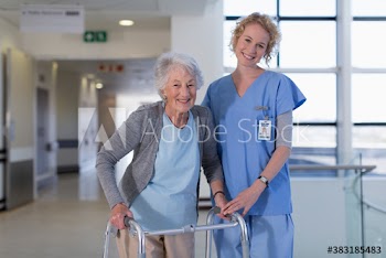 Portrait smiling female nurse helping senior woman with walker in hospital