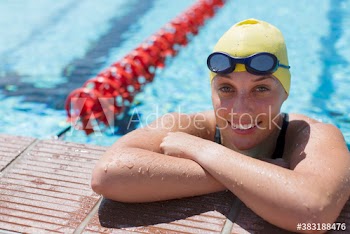 Portrait smiling female swimmer in sunny swimming pool