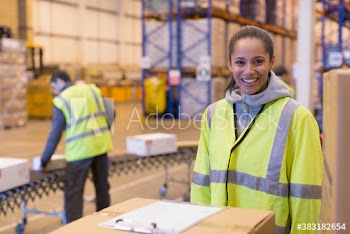 Portrait smiling female worker in distribution warehouse