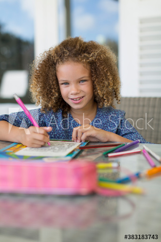 Portrait smiling girl coloring at table