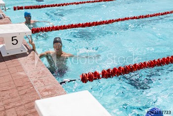 Portrait smiling male swimmer ready in sunny swimming pool