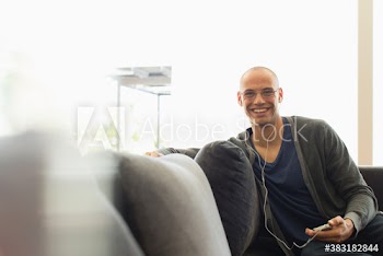 Portrait smiling man listening to music on sofa