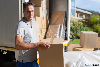 Portrait smiling man moving cardboard boxes from moving van