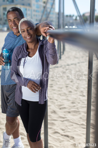 Portrait smiling senior couple exercising on beach