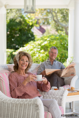 Portrait smiling senior couple on morning patio