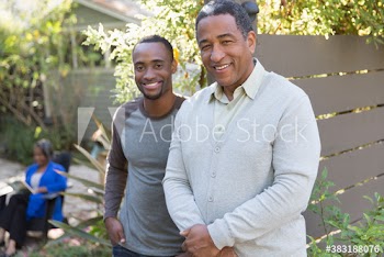 Portrait smiling senior father and adult sun on patio