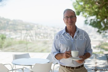 Portrait smiling senior man drinking coffee on patio