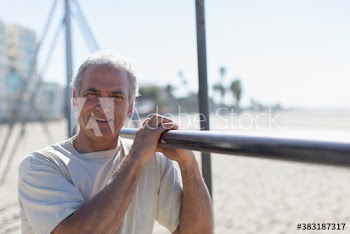 Portrait smiling senior man exercising on sunny beach