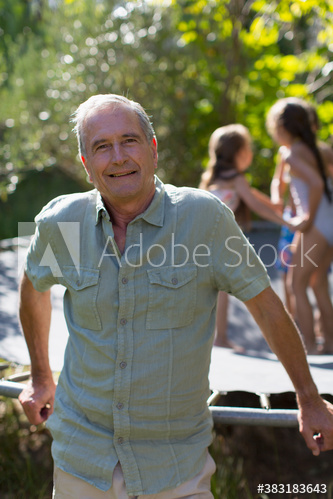 Portrait smiling senior man leaning on trampoline