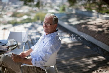 Portrait smiling senior man relaxing on patio