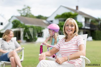 Portrait smiling senior woman with family in sunny garden
