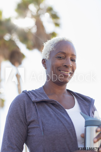 Portrait smiling senior woman with water bottle exercising