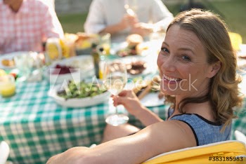Portrait smiling woman enjoying wine with lunch on sunny patio