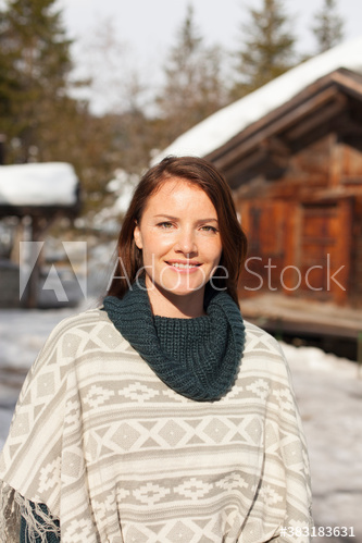 Portrait smiling woman outside sunny snowy cabin