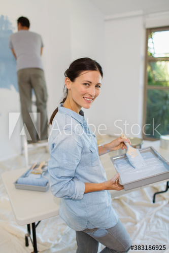 Portrait smiling woman painting at home