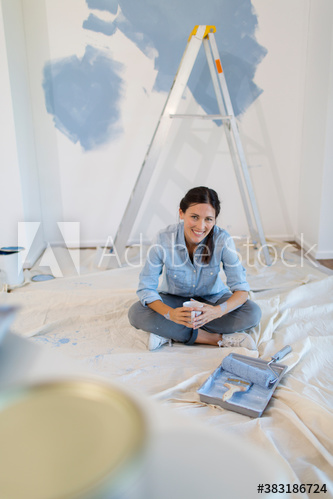 Portrait smiling woman painting room blue