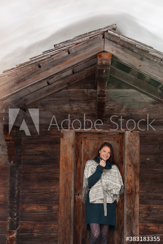 Portrait smiling woman standing in wood cabin doorway