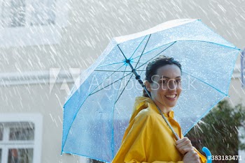 Portrait smiling woman with umbrella in rain