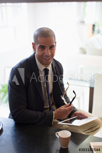 Portrait smiling young businessman in suit using digital tablet