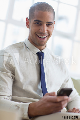Portrait smiling young businessman using smart phone