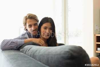 Portrait smiling young couple relaxing on sofa