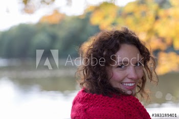 Portrait smiling young woman at autumn riverside