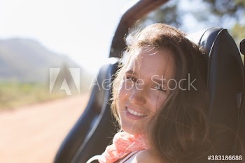 Portrait smiling young woman riding in sunny jeep