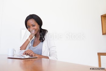 Portrait smiling young woman using digital tablet and drinking coffee