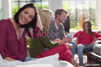 Portrait smiling young woman with roommates on sofa