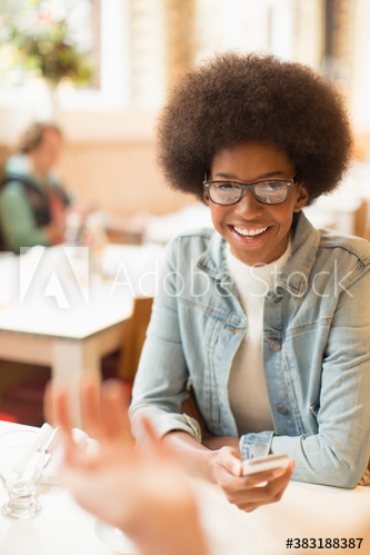 Portrait smiling young woman with smart phone in cafe